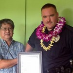 Aloha Exchange President Dale Tokuuke presents an 'Officer of the Month' award to Officer Michael Santos