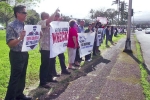 side shot of sign wavers facing the road