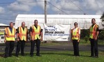 Image of officers and civilians with a sign that says, 'DRUNK DRIVING Over the limit. Under arrest.'