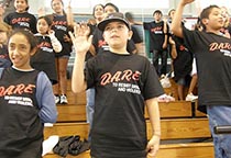 students wearing DARE t-shirts raise their right hands
