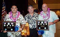 Image: Honored officers wearing leis and holding plaques pose with the deputy chief.