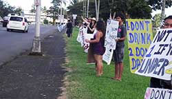 Image: Group waving signs along highway.