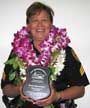 Iwamoto in leis holding plaque