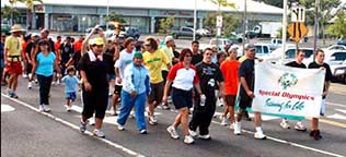 A group of participants stand with a banner reading "Special Olympics Training for Life"